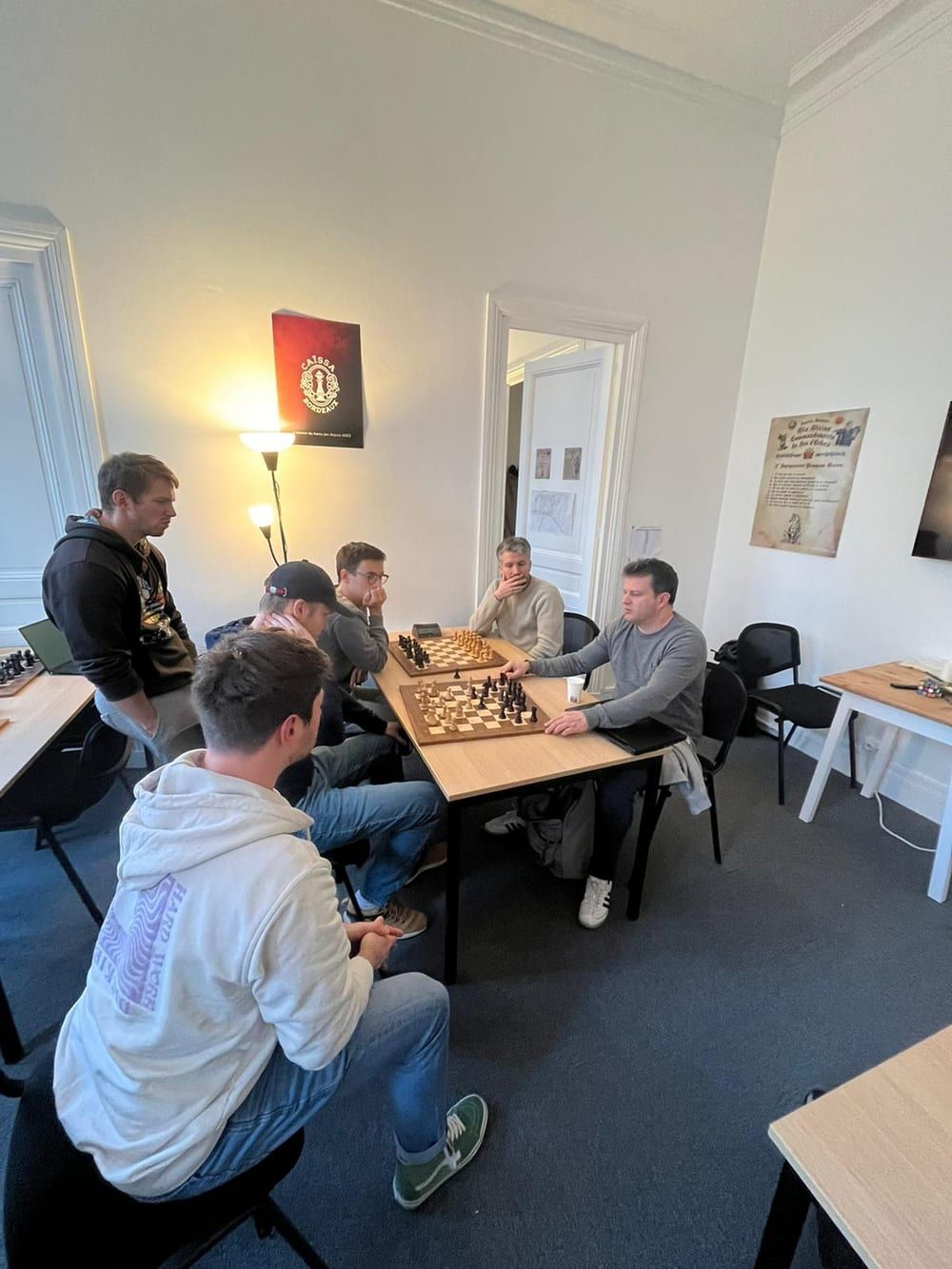 Chess masterclass, a group of students around a board analyzing
