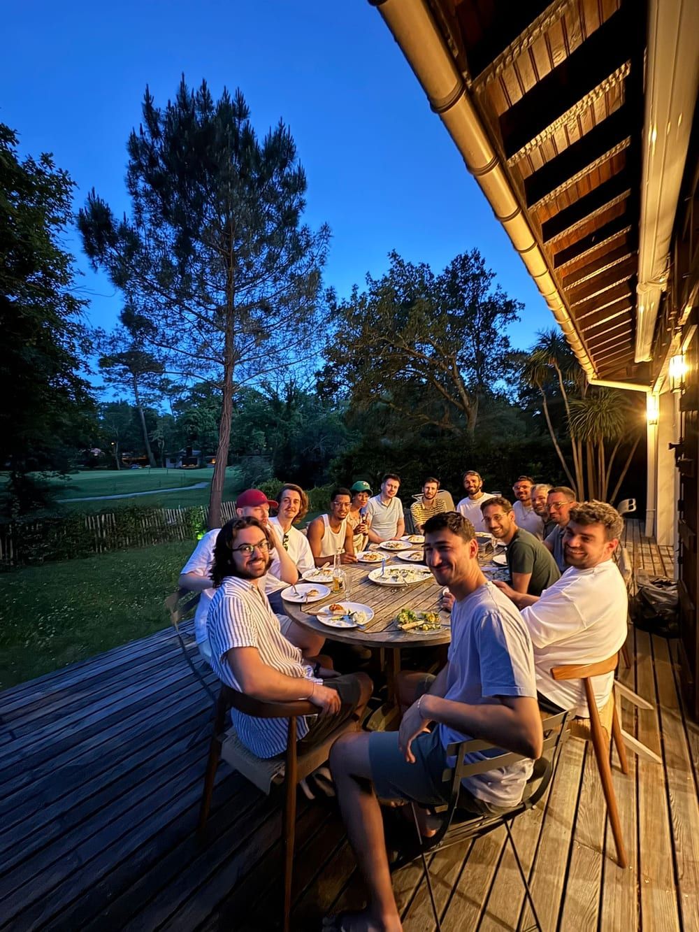 Players gathered around an evening meal on a terrace, lodged together during a tournament